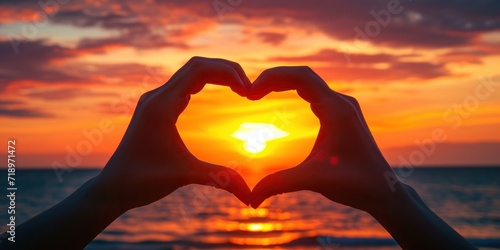 A close-up of hands forming a heart shape with a beautiful sunset in the background - love and togetherness concept Ideal for romantic themes and greeting cards