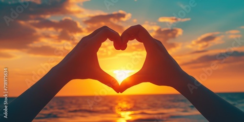 A close-up of hands forming a heart shape with a beautiful sunset in the background - love and togetherness concept Ideal for romantic themes and greeting cards