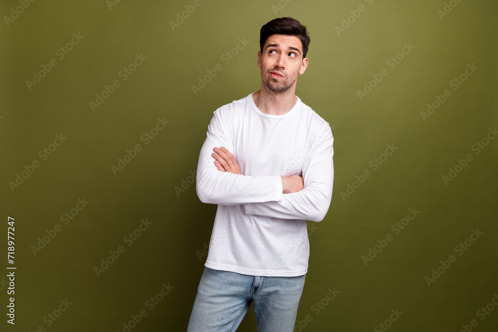 Photo of young doubtful confident man wear white sweatshirt crossed arms looking empty space unsure isolated on khaki color background Photo of young doubtful confident man wear white sweatshirt crossed arms looking empty space unsure isolated on khaki color background
