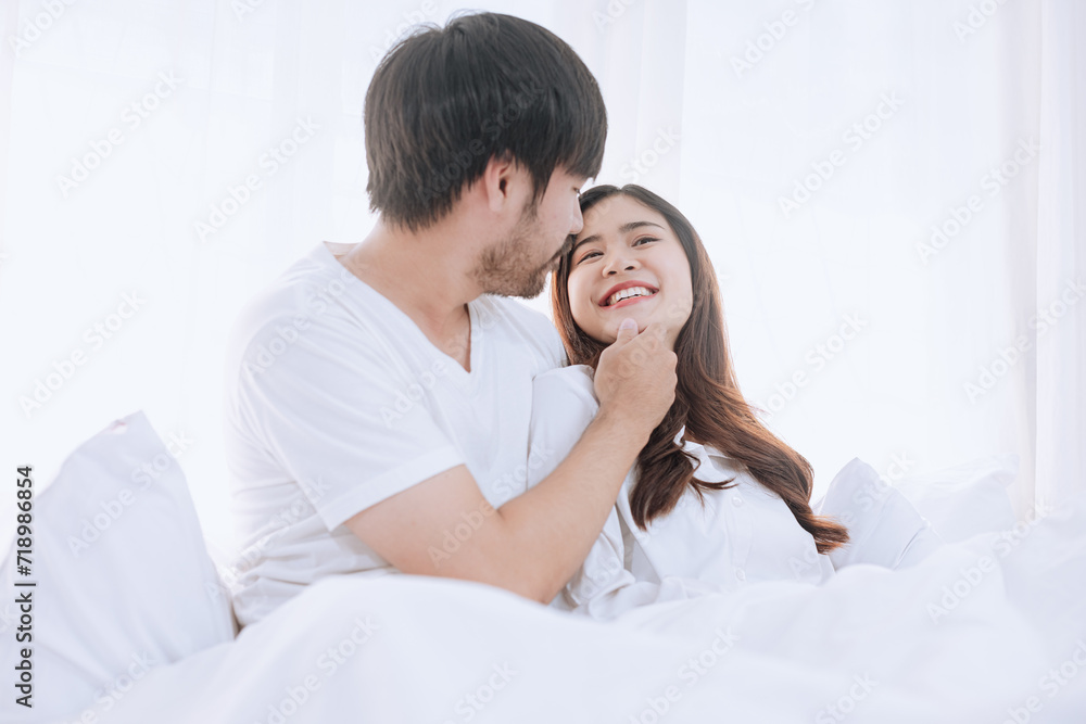 Happy love Asian young man and woman staying together in bedroom, Valentine's Day, Concept of holiday and surprise. Happy love Asian young man and woman staying together in bedroom, Valentine's Day, Concept of holiday and surprise.