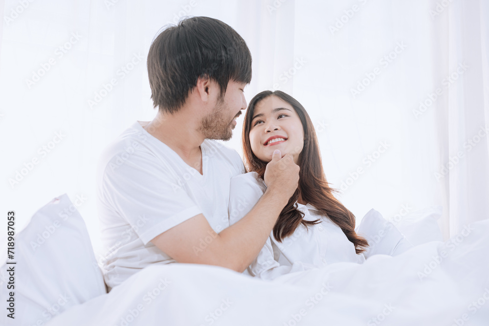 Happy love Asian young man and woman staying together in bedroom, Valentine's Day, Concept of holiday and surprise. Happy love Asian young man and woman staying together in bedroom, Valentine's Day, Concept of holiday and surprise.