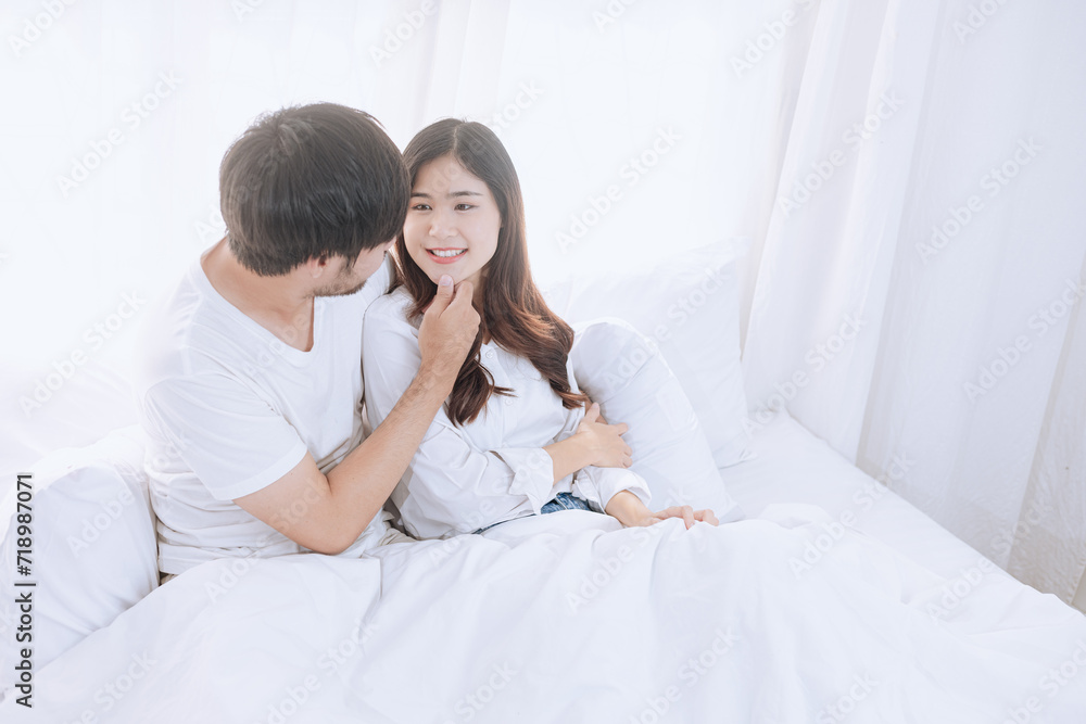 Happy love Asian young man and woman staying together in bedroom, Valentine's Day, Concept of holiday and surprise. Happy love Asian young man and woman staying together in bedroom, Valentine's Day, Concept of holiday and surprise.