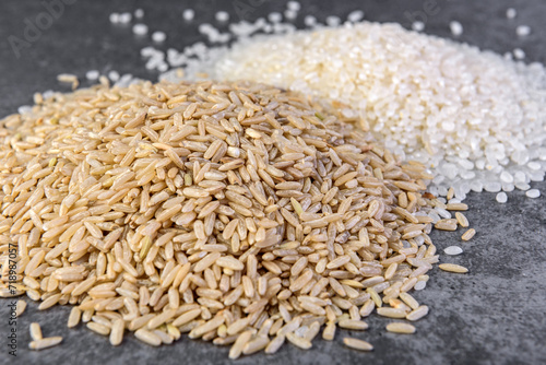 White and brown rice on gray background.
