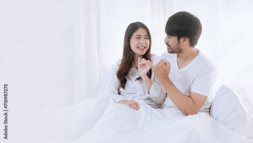 Happy love Asian young man and woman staying together in bedroom, Valentine's Day, Concept of holiday and surprise. Happy love Asian young man and woman staying together in bedroom, Valentine's Day, Concept of holiday and surprise.