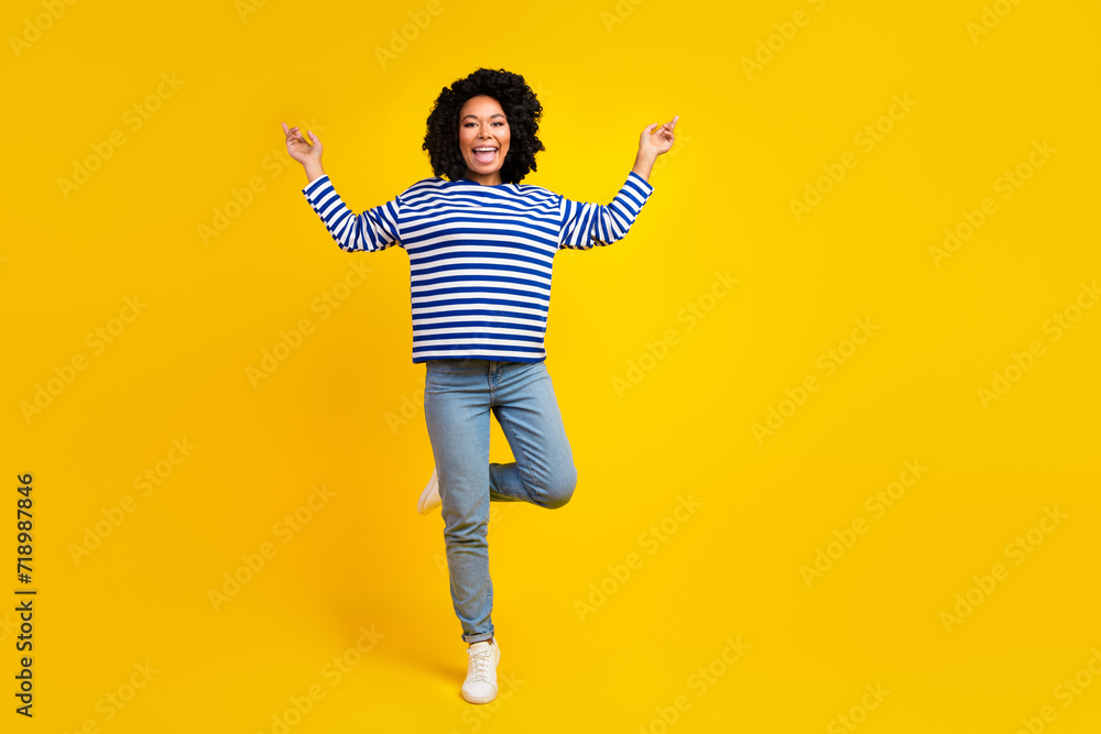 Full length photo of positive good mood girl wearing stylish clothes balancing one leg empty space isolated yellow color background Full length photo of positive good mood girl wearing stylish clothes balancing one leg empty space isolated yellow color background