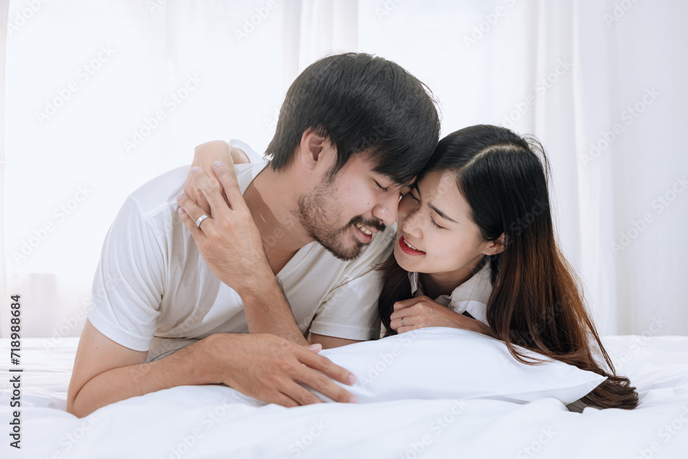 Happy love Asian young man and woman staying together in bedroom, Valentine's Day, Concept of holiday and surprise. Happy love Asian young man and woman staying together in bedroom, Valentine's Day, Concept of holiday and surprise.