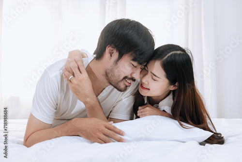 Happy love Asian young man and woman staying together in bedroom, Valentine's Day, Concept of holiday and surprise. © SOMKID