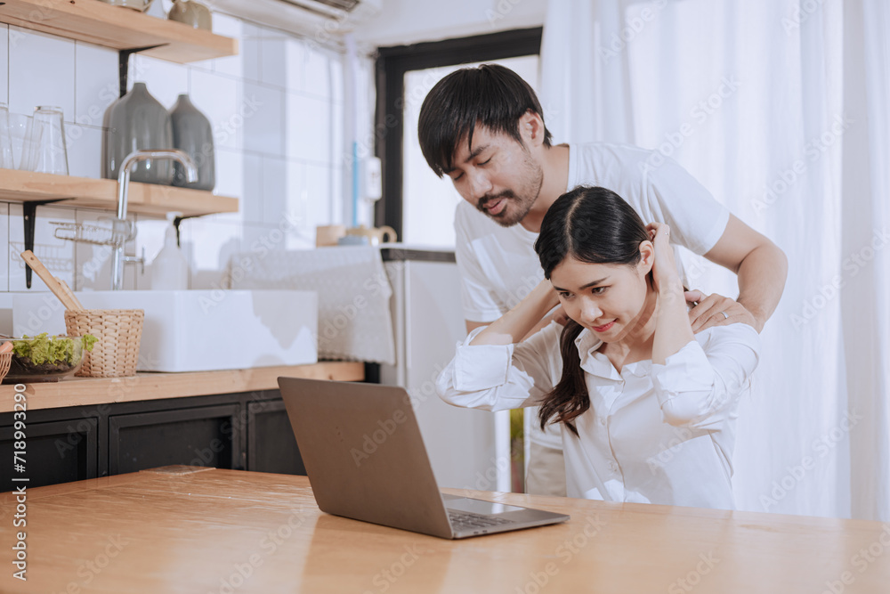 Happy love Asian young man and woman using laptop together in the kitchen relaxing at home. Happy love Asian young man and woman using laptop together in the kitchen relaxing at home.