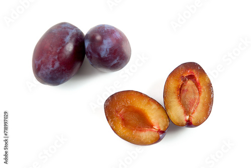 Two Whole and Halves purple plums isolated on white background. .