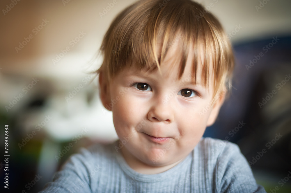 Happy cute smiling baby boy captures our attention with his mesmerizing gaze as he looks directly at the camera. Joy and happiness concept. Love and family emotion