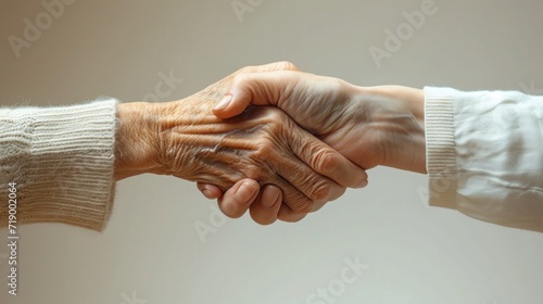 hand of an old and a young person holding together, care and respect.