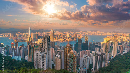 Wonderful panoramic of Hong Kong city view from Victoria Peak, modern cityscape during sunset in the evening with amazing sun light cumulus clouds.