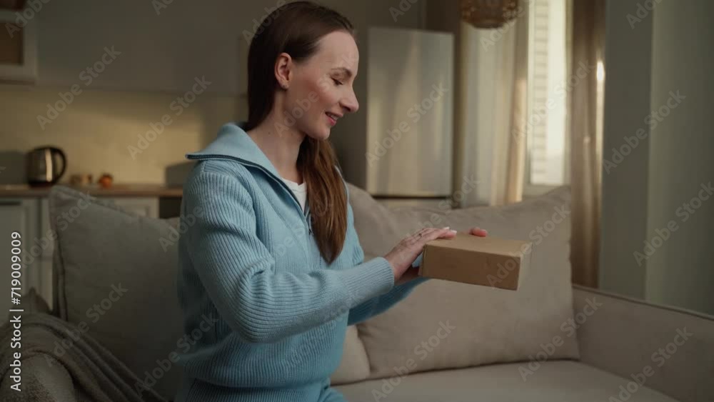 Beautiful young woman receives a parcel from a courier at home with good service thanks to online shopping. The courier delivers the parcel in a cardboard box. Beautiful young woman receives a parcel from a courier at home with good service thanks to online shopping. The courier delivers the parcel in a cardboard box.