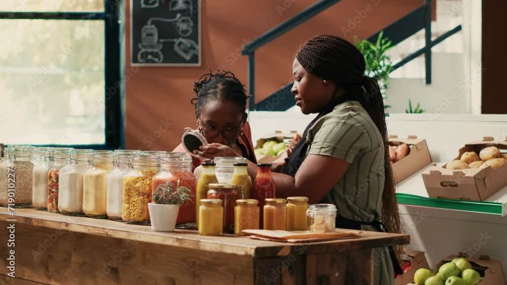 Storekeeper offering food sample for a taste test in supermarket, advertising eco friendly homemade products. Vendor providing amazing customer service, recommending various bulk items. Storekeeper offering food sample for a taste test in supermarket, advertising eco friendly homemade products. Vendor providing amazing customer service, recommending various bulk items.