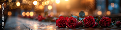 Romantic Valentine's Day celebration with a bouquet of red roses on a wooden table. Elegant panoramic header for websites with space for text. Horizontal still life. Bokeh effect. Love symbol banner photo