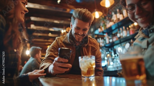 Close-up of a man using his cell phone while with friends in a bar.