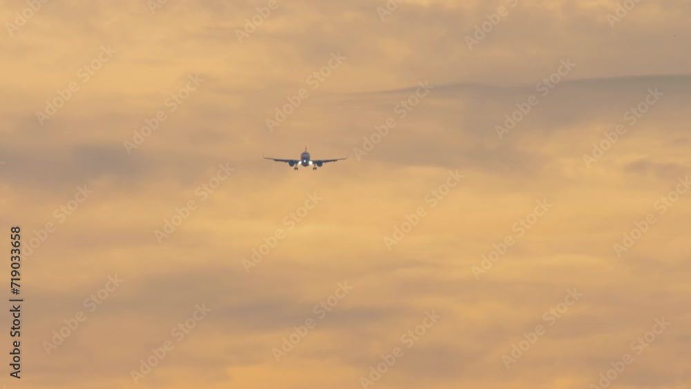 Jet plane approaching to land, descending at the sunset sky. Footage of an airplane flying, front view. Tourism and travel concept. Aircraft arriving Jet plane approaching to land, descending at the sunset sky. Footage of an airplane flying, front view. Tourism and travel concept. Aircraft arriving