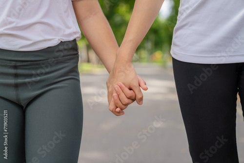 Older sister and younger sister walking in the park Feel comfortable on holidays and relax and exercise.