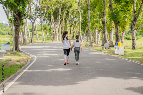 Older sister and younger sister walking in the park Feel comfortable on holidays and relax and exercise.