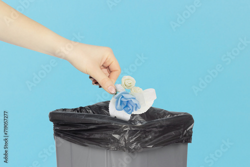 throw boutonniere in the trash, boutonniere in hand in front of trash can, concept of ruined holiday