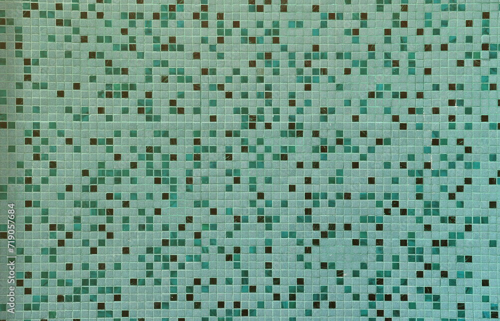 The texture of the wall, decorated with a mosaic of various small square tiles. Abstract pattern of ceramic tiles on the wall The texture of the wall, decorated with a mosaic of various small square tiles. Abstract pattern of ceramic tiles on the wall