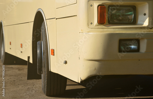 Photo of the hull of a large and long yellow bus. Close-up front view of a passenger vehicle for transportation and tourism