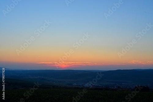 Landscape at twilight with red sky. Romantic sunset with red clouds. Countryside during the blush of dawn