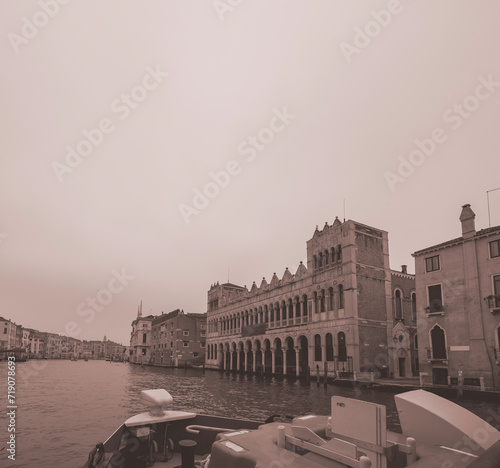 Facades of weathered buildings with windows on street of Venice city near canal water in daylight