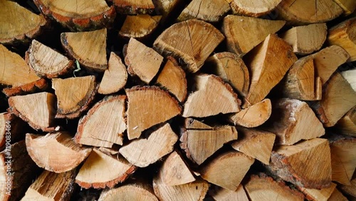 Chopped oak firewood stacked in a woodshed for the winter, close-up. Background of firewood for heating the house, camera movement