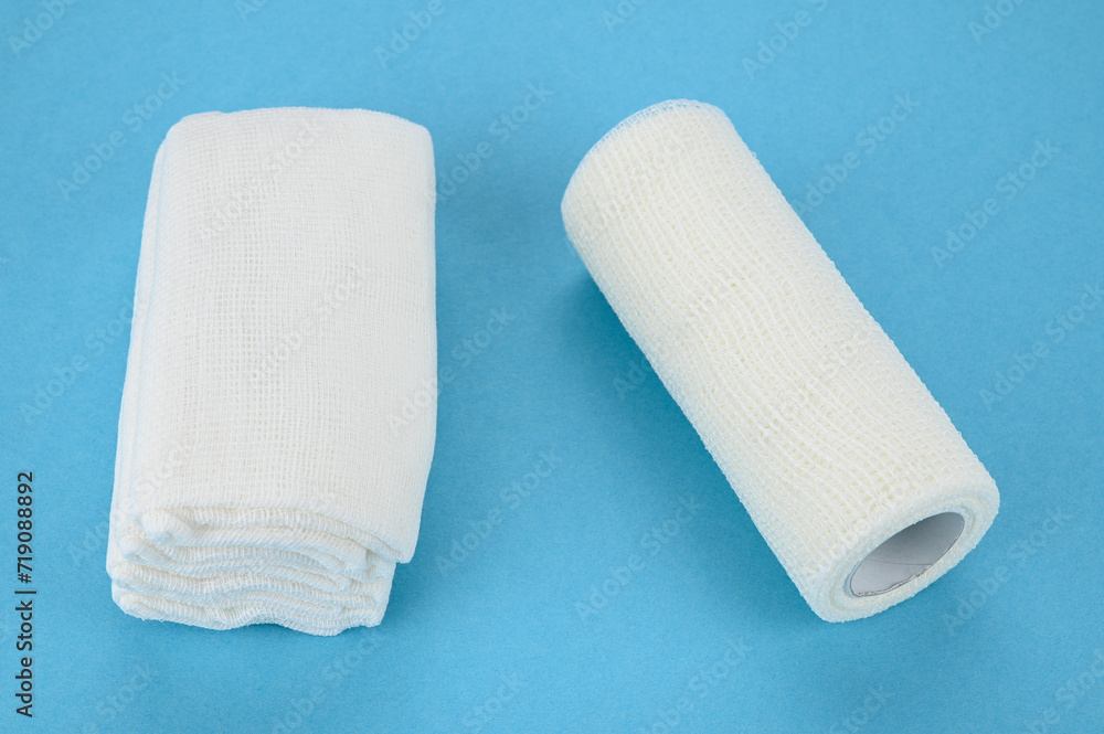 Fototapeta premium Self-fixing cohesive bandage and gauze sterile wipes, on a blue background.