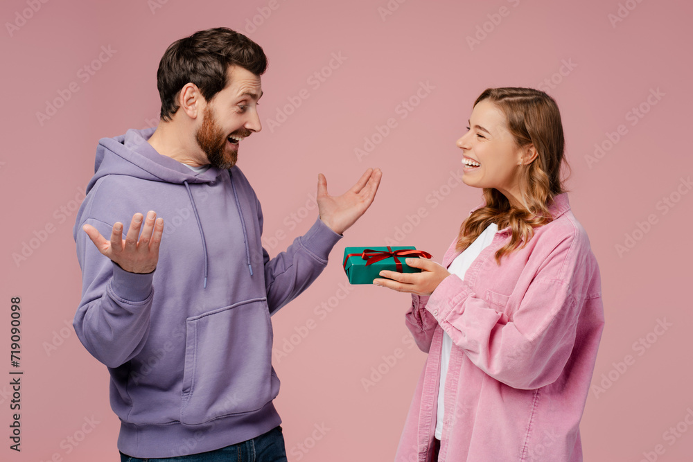 Attractive happy couple holding gift box celebration birthday isolated on pink background. Dating, love, Valentines day Attractive happy couple holding gift box celebration birthday isolated on pink background. Dating, love, Valentines day