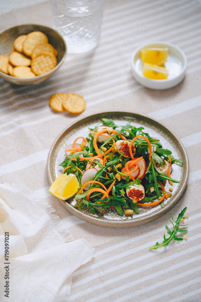 salad with greens, arugula and carrots, light background, daylight, no people, close up