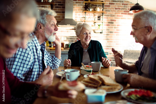Group of senior friends enjoying conversation and breakfast together
