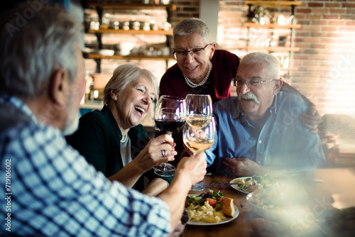 Senior friends sharing a meal and laughter at home