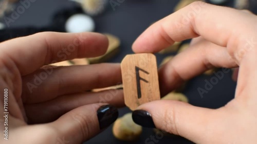 Wooden runes in hand on black table background. Scandinavian magical esoteric symbols and signs for divination and prediction of the future and destiny, esotericism concept. photo