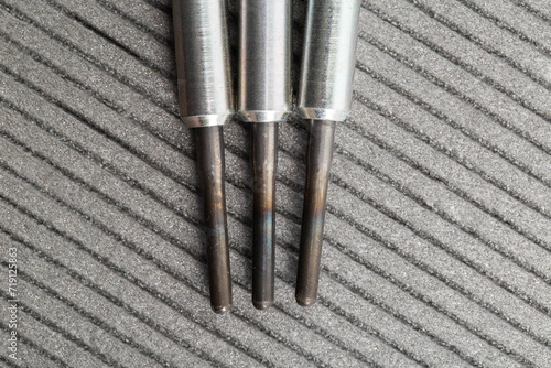 Modern rod ceramic glow plugs for easier starting of a diesel engine in cold weather on a gray background. Automotive spare part, heating element. photo