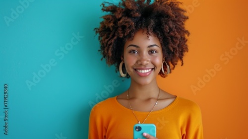 portrait of young african american woman holding her mobile and making an ons...