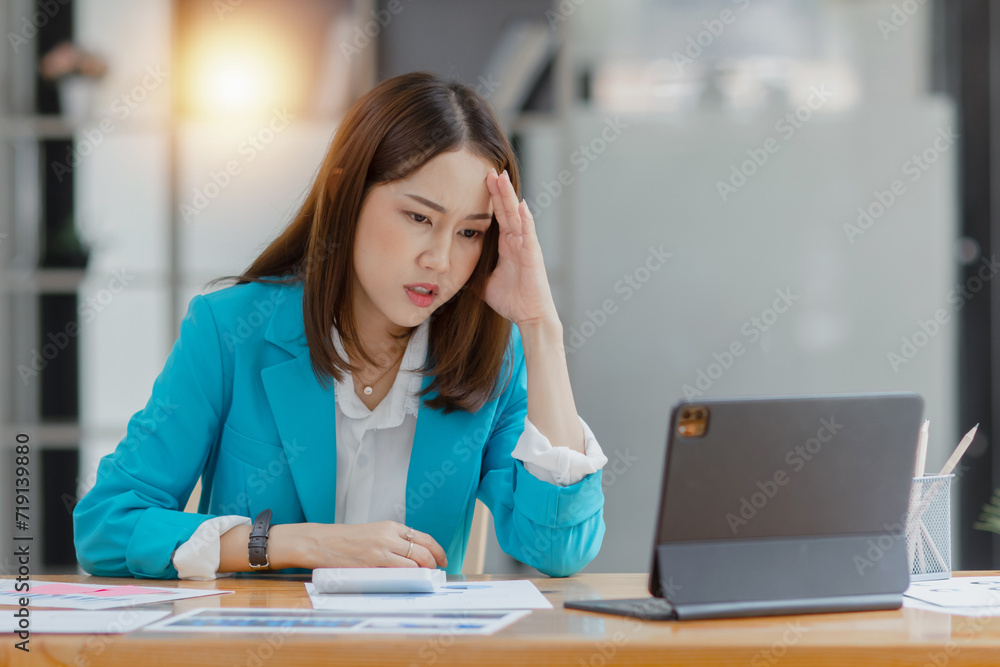 Asian businesswoman working on tablet with documents and stressed over worked from work in the office, Tired and Overworked businesswoman concept. Asian businesswoman working on tablet with documents and stressed over worked from work in the office, Tired and Overworked businesswoman concept.
