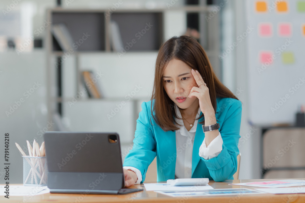 Asian businesswoman working on tablet with documents and stressed over worked from work in the office, Tired and Overworked businesswoman concept. Asian businesswoman working on tablet with documents and stressed over worked from work in the office, Tired and Overworked businesswoman concept.