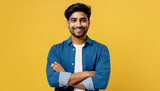 Young smiling happy cheerful Indian man he wearing shirt casual clothes look camera hold hands crossed folded look camera isolated on plain yellow color background studio portrait. Lifestyle concept