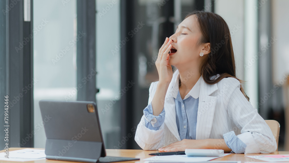 Asian businesswoman working on tablet with documents and stressed over worked from work in the office, Tired and Overworked businesswoman concept. Asian businesswoman working on tablet with documents and stressed over worked from work in the office, Tired and Overworked businesswoman concept.