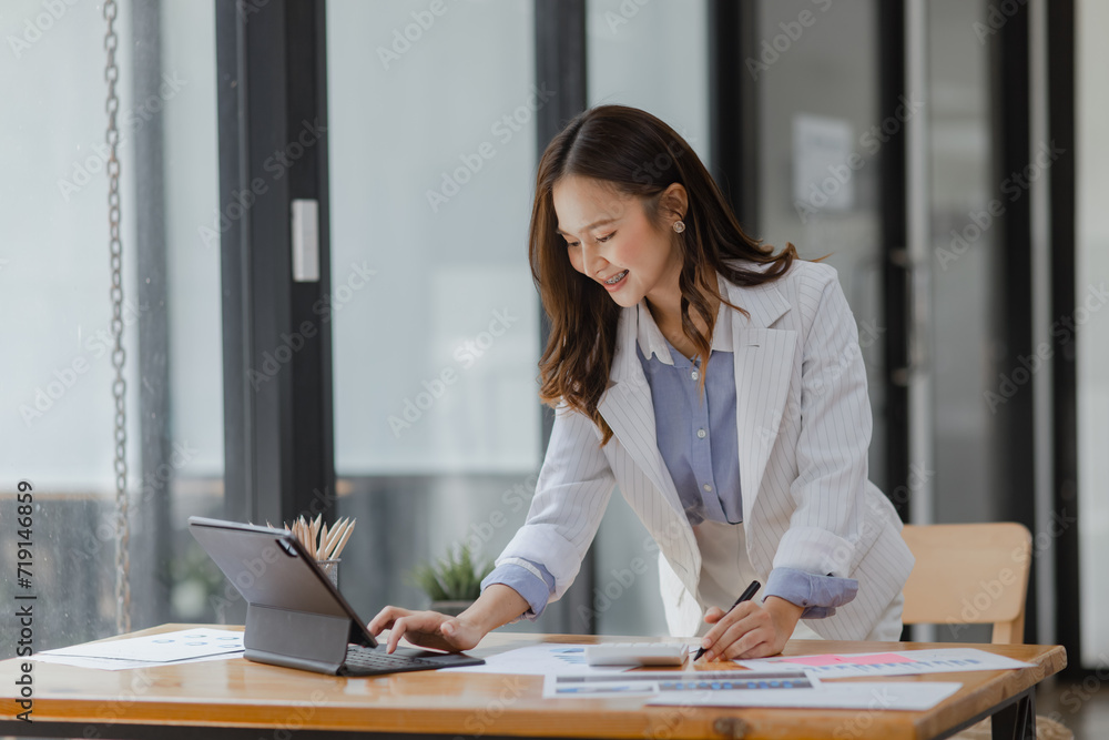 Asian Businesswoman working with tablet computer at office desk, Business accounting analysis report and financial concept. Asian Businesswoman working with tablet computer at office desk, Business accounting analysis report and financial concept.