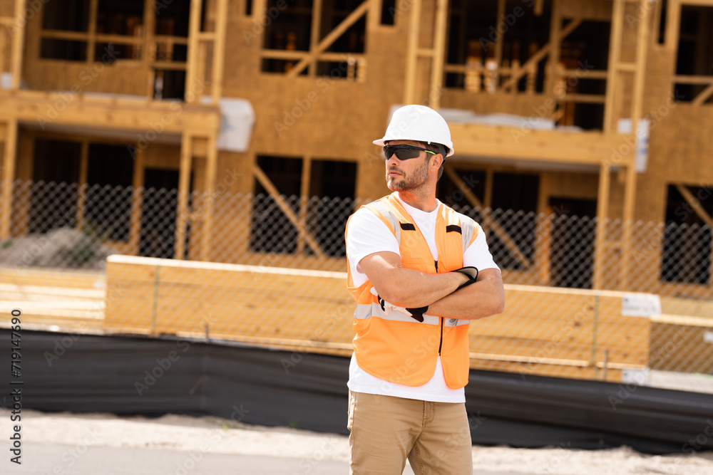 roofer builder working on roog structure of building on construction site. handsome young male builder in hard hat smiling at camera. Construction Worker on Duty. Contractor and the Wooden House Frame roofer builder working on roog structure of building on construction site. handsome young male builder in hard hat smiling at camera. Construction Worker on Duty. Contractor and the Wooden House Frame