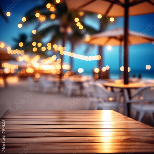 Empty wooden table and abstract blurred background of cafe with bokeh light. Wooden table with blur beach cafes background and bokeh lights created