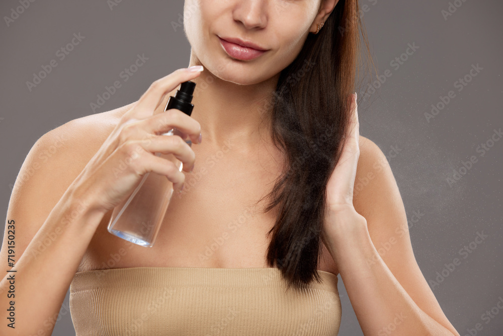Haircare product advertisement showcasing a nourishing hair mist. Close-up of woman spraying product on her hair, focus on the spray mist. Concept of natural beauty, cosmetology, cosmetics, skin care Haircare product advertisement showcasing a nourishing hair mist. Close-up of woman spraying product on her hair, focus on the spray mist. Concept of natural beauty, cosmetology, cosmetics, skin care