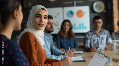 Big data analysis and fintech e-commerce concept with middle eastern descent woman as executive director presenting growth statistics to diverse conference meeting members in the office with graphs