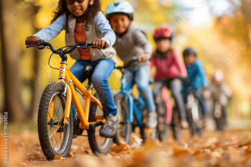 a diverse group of kids enjoying a group bike ride in the autumn park © Kien