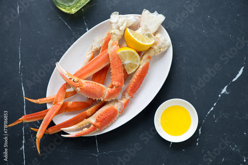 Plate with boiled opilio or snow crab on a black marble background, horizontal shot, view from above