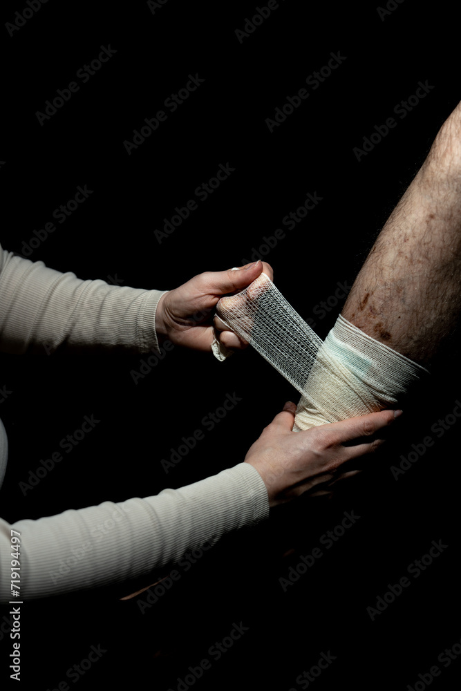 Nurse removing bandage from male patient