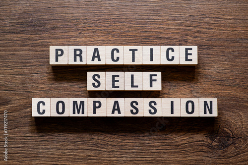 Practice self compassion - word concept on building blocks, text photo